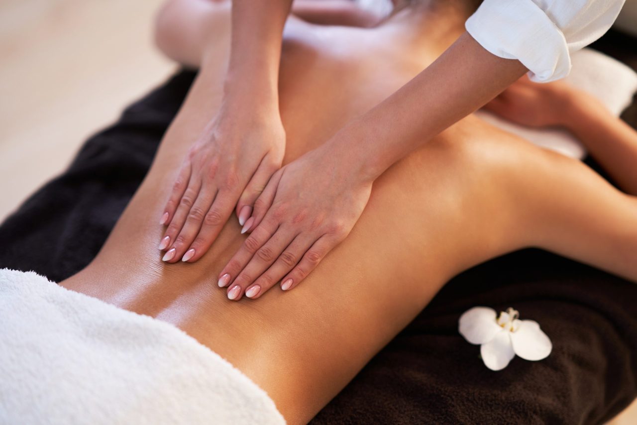 Relaxed woman receiving back massage Best Massages for Lower Back Pain in Safety Harbor